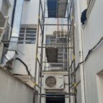 Andaime montado em corredor estreito entre edifícios para manutenção de ar-condicionado em altura — Alto da Lapa e região