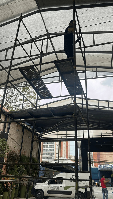 Profissional realizando serviço em altura sobre andaime metálico em Barueri